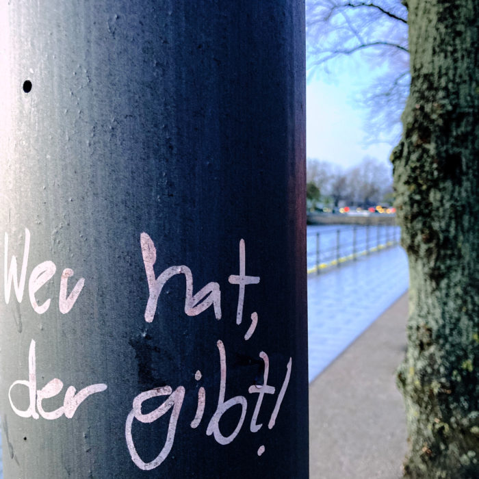 Schrift an einer Laterne: Wer hat, der gibt