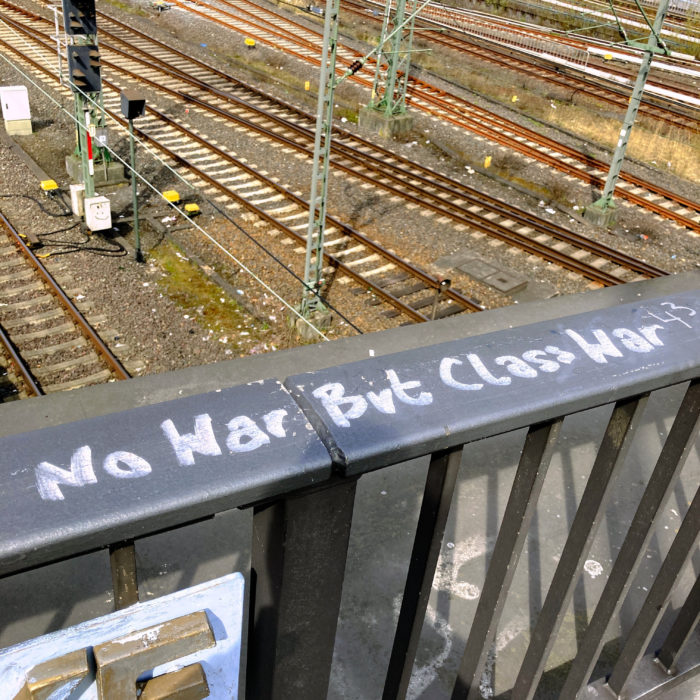 Eon Spruch auf einem Geländer am Bahnhof: No war but class war
