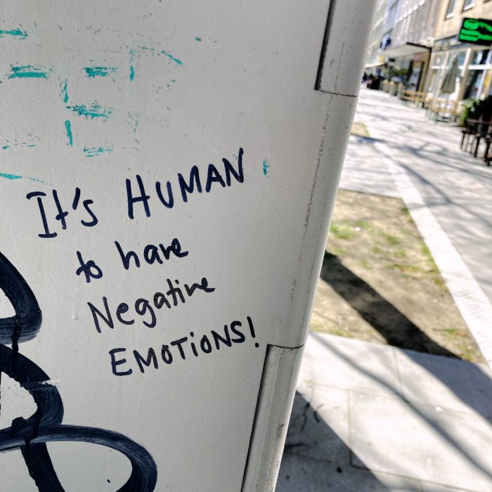 Ein Schriftzug auf einem Stromkasten. "It's human to have negative emotions"