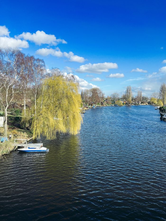 Blick von der Braunen Brücke über die Bille an einem sonnigen Vorfrühlingstag, wenige weiße Wolken im Bild vor sehr blauem Himmel.