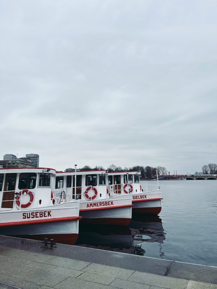 Drei Schifffe der weißen Flotte am Anleger an der Binnenalster, man sieht die Namen Susebek, Ammersbek und Sielbek.