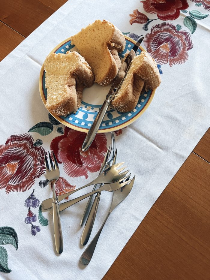 Eine Platte mit Kuchen auf einer bunt bestickten Tischdecke