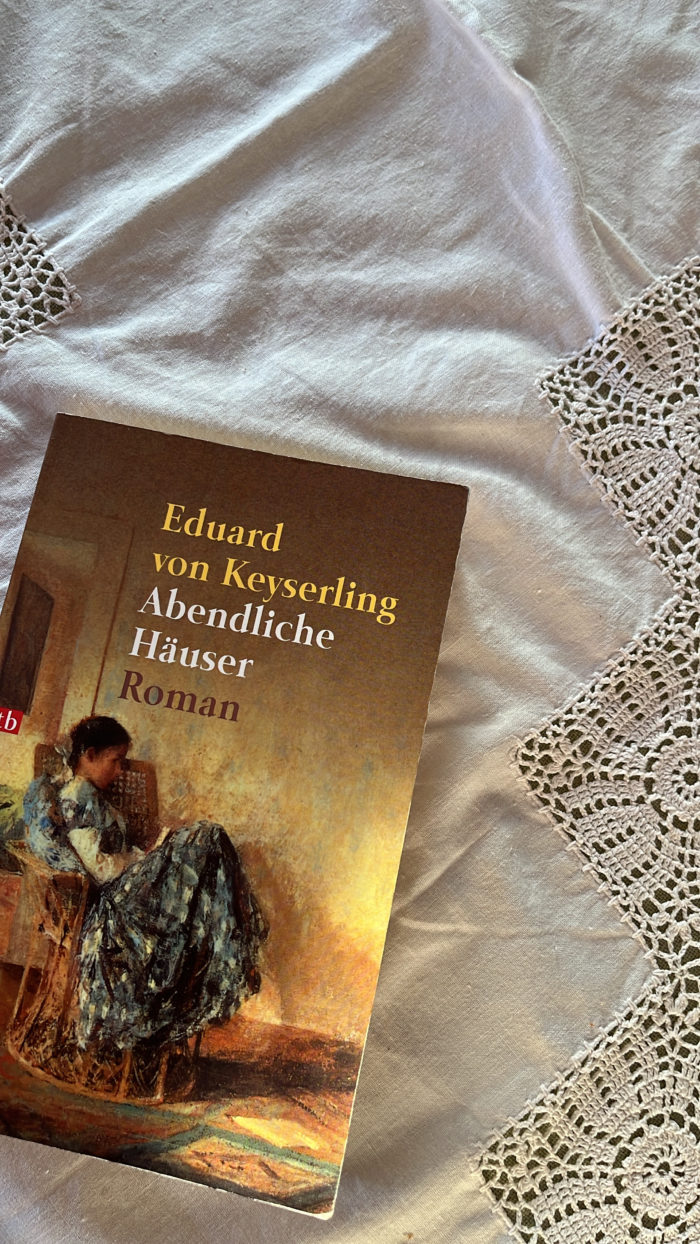 Das Buch "Abendliche Häuser" von Keyserling. Auf dem Cover das Gemälde einer lesenden Frau in einem Korbstuhl