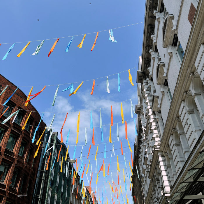 Bunte Bänder vor blauem Himmel als Deko über der Straße Große Bleichen