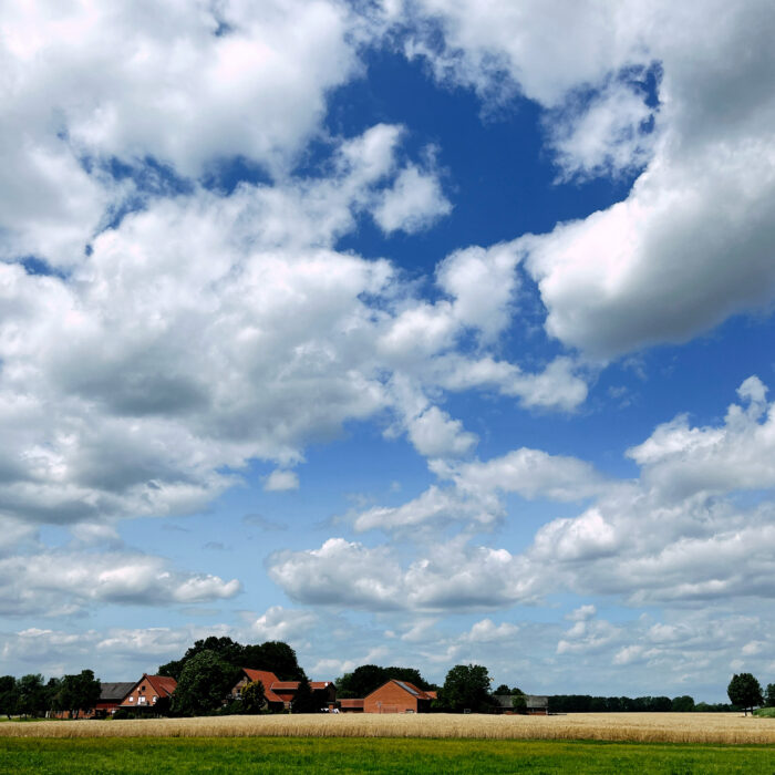 Blauer Himmel mit weißen Wolken über Nordostwestfalen, Bauernhäuser und Getreidefelder