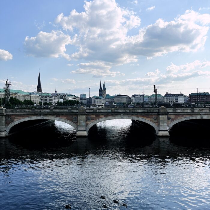 Blick von der Kennedybrücke auf die Hamburger Innenstadt, Sommerhimmel, weiße Wolken, das Rathaus und Kirchtürme