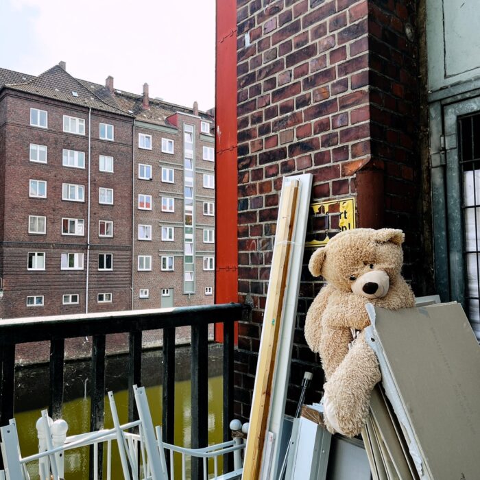 Ein vermutlich ausgesetzter Plüschteddy auf einem Stapel Sperrmüll, Bretter und Leisten