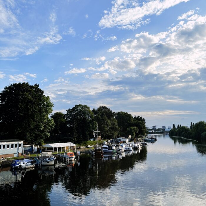 Das Ufer der Bille mit Motorbooten an Stegen an der Billerhuder Insel
