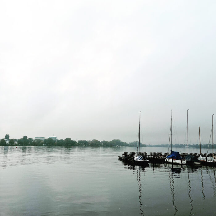 Segelboote unter Planen an einem Steg an der Außenalster. nebliges Licht, Herbststimmung