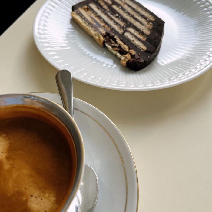 Ein Teller mit einem Stück Kalter Hund und einer Tasse Espresso