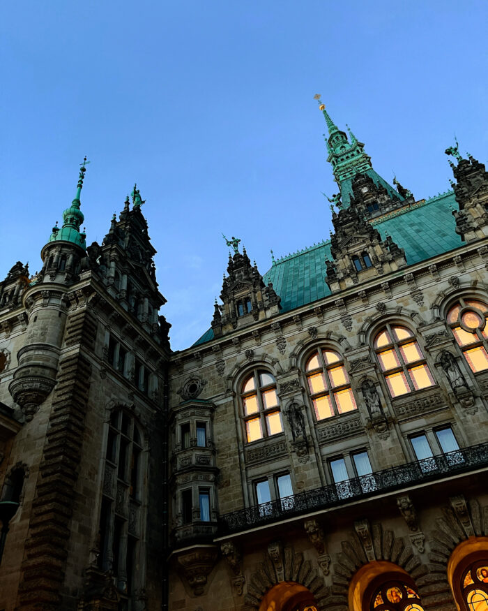 Das Hamburger Rathaus, die Abendsonne spiegelt sich in den Fenstern, vom Innenhof aus aufgenommen