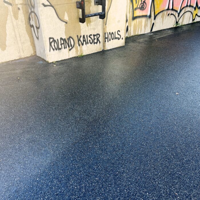 Ein gesprühter Schriftzug an einer Wand: Roland Kaiser Hools