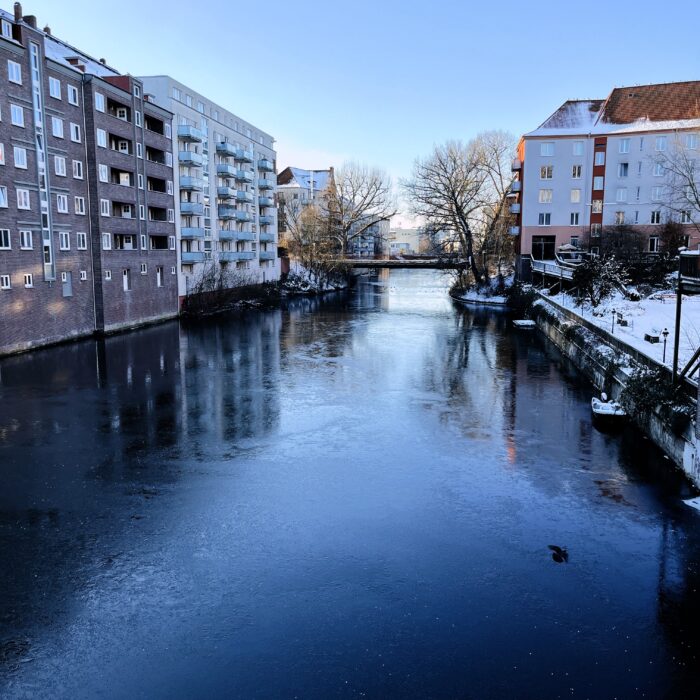 Blick über ein Fleet in Hamburg-Hamm, das Wasser friert, das Licht ist sonnig-winterlich