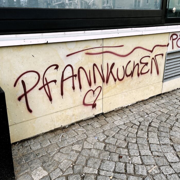 Ein Graffiti an einer Hauswand "Pfannkuchen" als ziemlich großgeschriebenes Wort, darunter ein Herz.