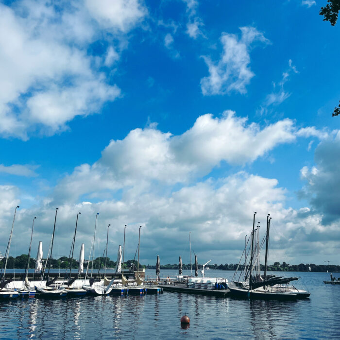 Segelboote an einem Steg an der Außenalster, bewölkter Himmel, sommerliche Anmutung