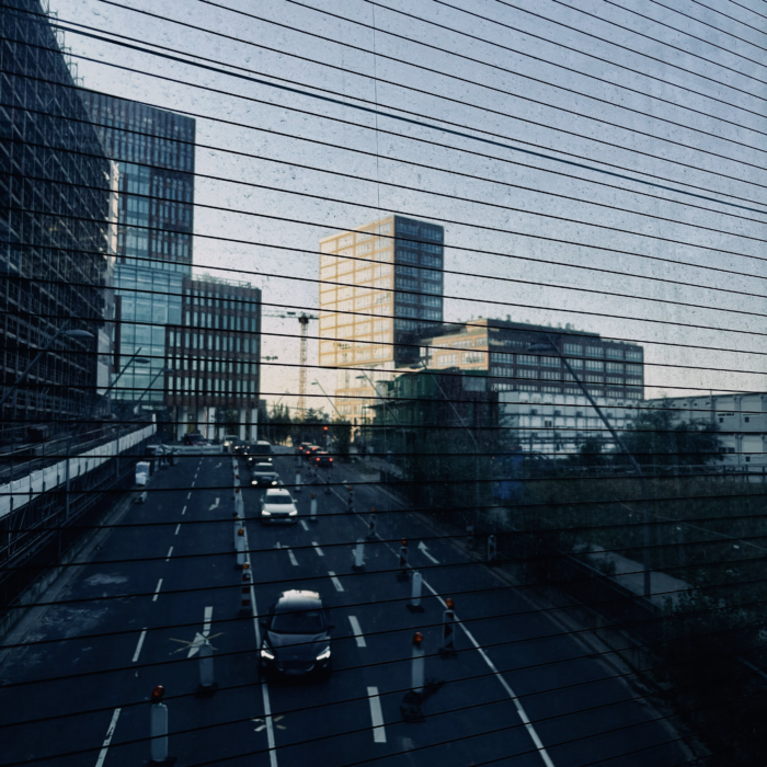 Blick durch die Scheiben der U-Bahn-Station Elbbrücken auf den Feierabendverkehr auf der Zweibrückenstraße, im Hintergrund noch neu wirkende Hochhäuser