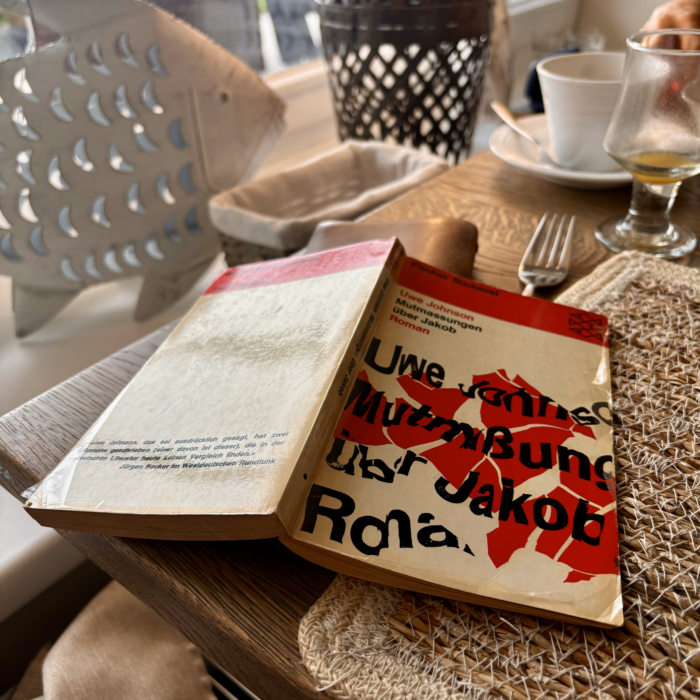 Das aufgeschlagene Buch "Mutmaßungen über Jakob" auf dem Hotelfrühstückstisch