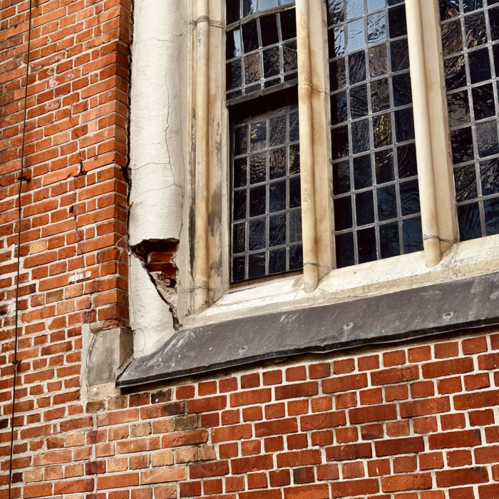 Außenmauer St. Petri, bröckelnde Ziegel an einem alten Fenster
