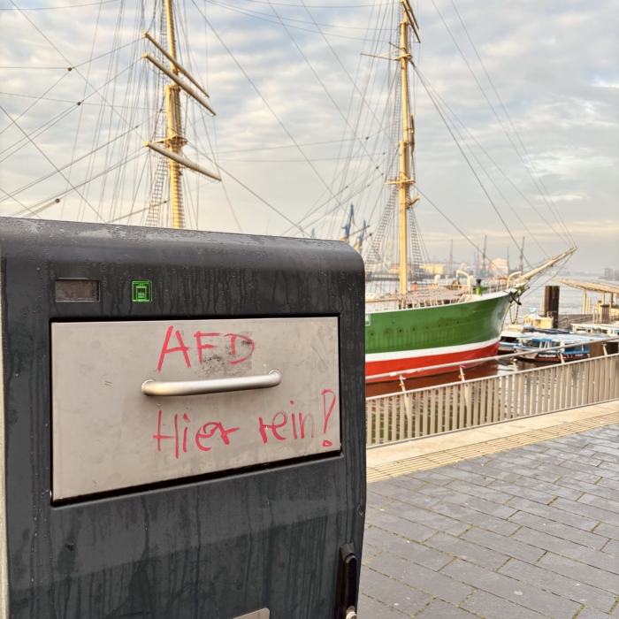 Ein Mülleimer im Hamburger Hafen, auf dem Deckel steht "AfD hier rein!", im Hintergrund die Rickmer Rickmers.