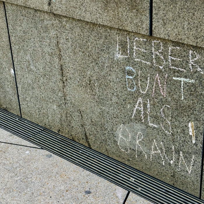 Kreideschrift an einer Wand: Lieber bunt als braun!