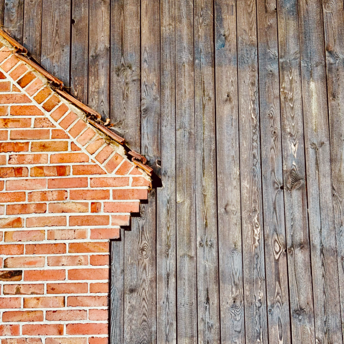 Dörfliche Wandstrukturen aus Holz und Ziegel