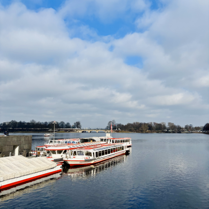 Boote der weißen Flotte am Anleger Jungfernstieg unter für Hamburger Verhältnisse recht blauem Himmel