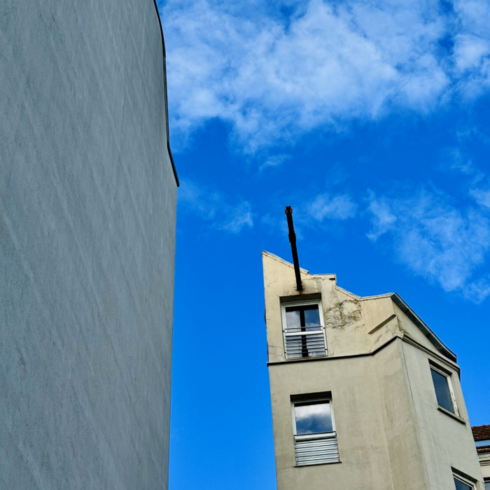 Die Setenansicht eines merkwürduig schmal wirkenden Altbaus in St. Georg vor blauem Himmel.