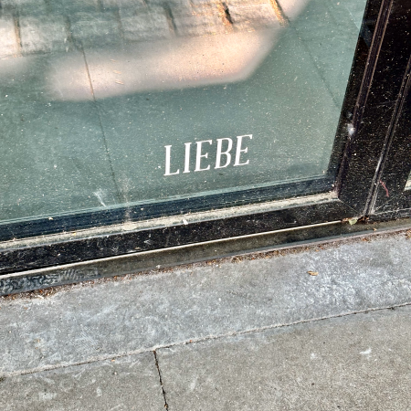 Der Schriftzug "Liebe" ganz unten an einem sehr dreckigen Schaufenster