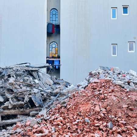 Ein Trümmerhaufen nach Hausabriss vor älterer Fassade
