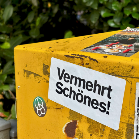 Ein Aufkleber auf einem Briefkasten mit der Aufschrift "Vermehrt Schönes!"