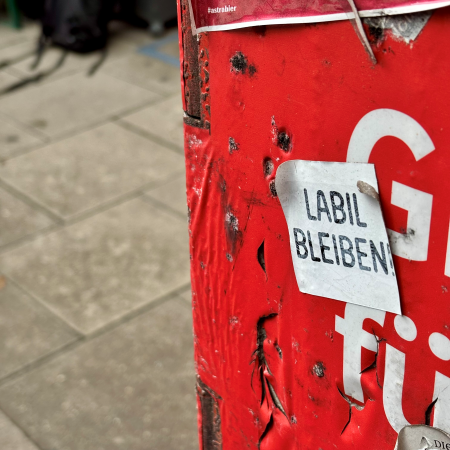 Ein Aufkleber auf einem roten Mülleimer der Stadt Hamburg: "Labil bleiben"
