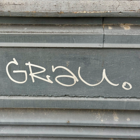 Schrift auf einer grauen Fassade: "Grau"