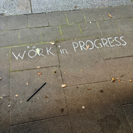 Kreideschrift auf dem Pflaster: Work in Progress