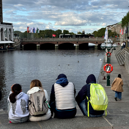 Touristen sitzen auf den Treppen an der Kleinen Alster