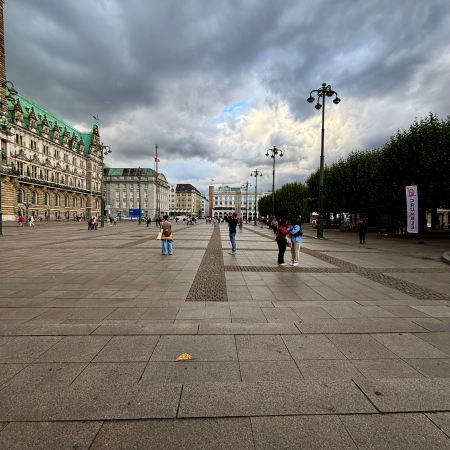 Der weitgehend leere Hamburger Rathausmarkt bei aufziehendem Regen im Weitwinkel
