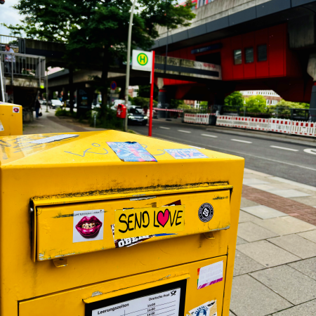 Ein Aufkleber "Send Love" auf einem Briefkasten vor der S-Bahn-Station Hammerbrook