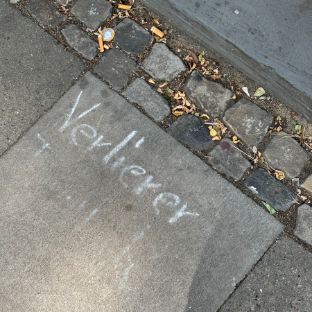Kreideschrift auf dem Pflaster: "Verlierer ..." Rest unleserlich