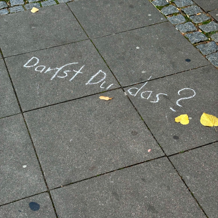 Kreideschrift auf dem Pflaster: Darfst du das?