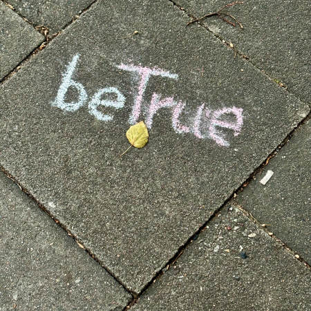 Kreideschrift auf dem Pflaster: Be true