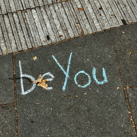 Kreideschrift auf dem Pflaster: Be you