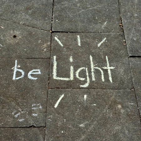 Kreideschrift auf dem Pflaster: Be Light