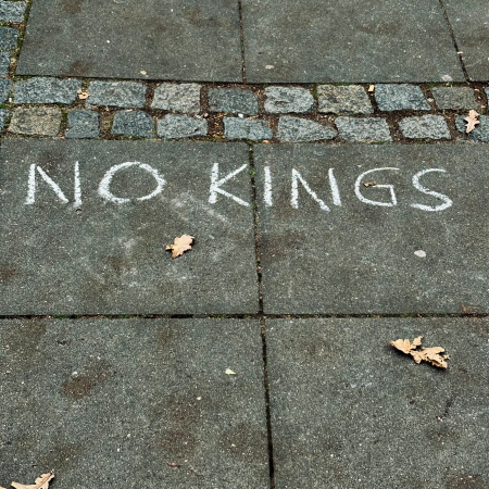 Kreideschrift auf dem Pflaster: No Kings