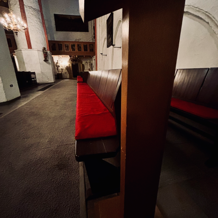 Eine leere Kirchenbank mit rotem Polster in St. Jacobi