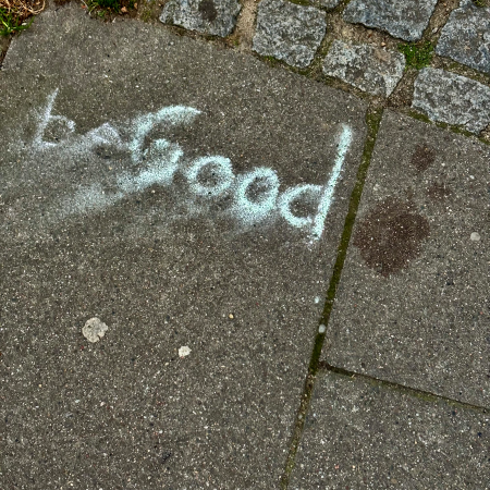 Kreideschrift auf dem Pflaster: Be Good