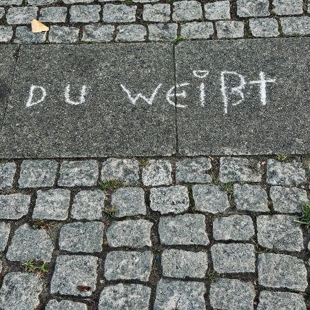 Kreideschrift auf dem Pflaster: "Du weißt"