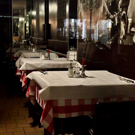 Blick durch das Fenster in ein nächtliches, leeres Restaurant