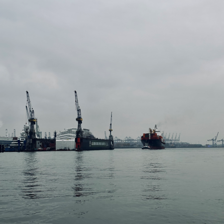 Ein Schlepper zieht ein Schiff elbaufwärts