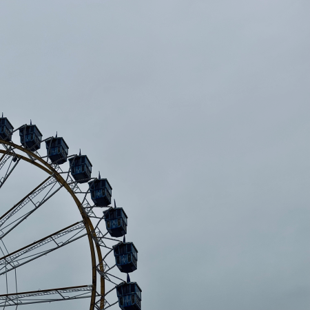 Unbeleuchtetes Riesenrad vor leerem Himmel