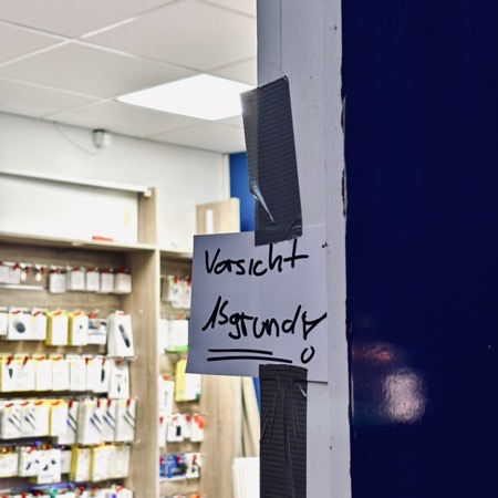 Ein Zettel an einer Ladentür mit der Aufschrift "Vorsicht Abgrund"!