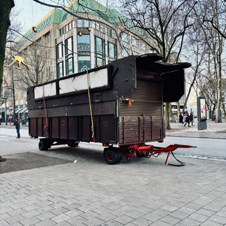 Eine auf einen LKW-Anhänger verladene Weihnachtsmarktholzhütte
